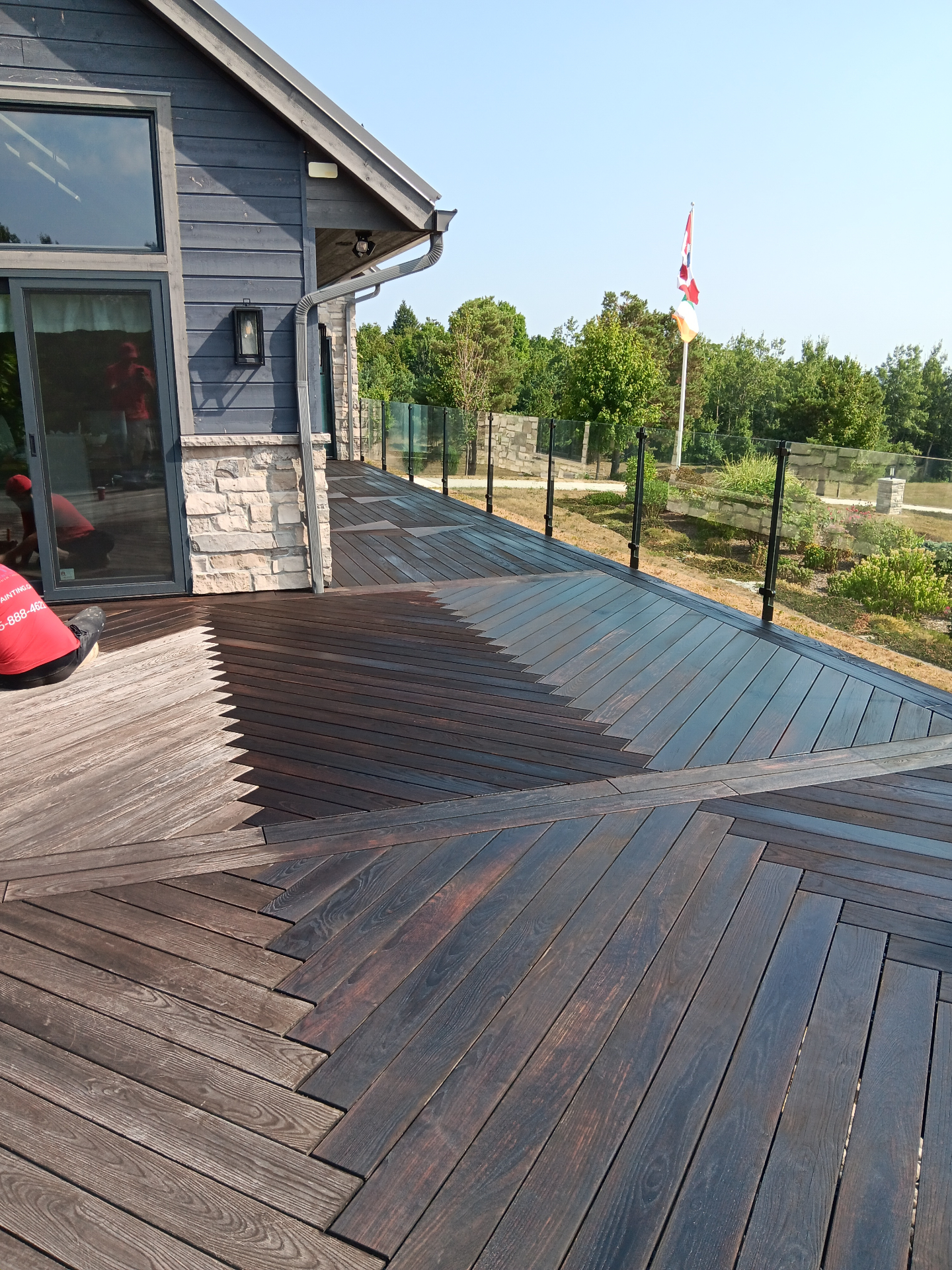 Completed deck staining project with stunning geometric pattern and dark finish