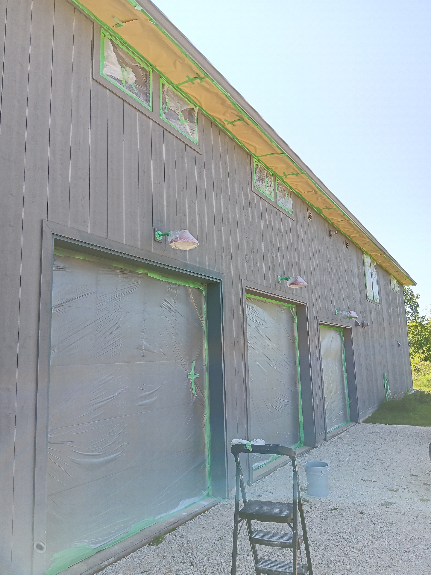 Garage exterior during painting - taped and prepped for fresh finish