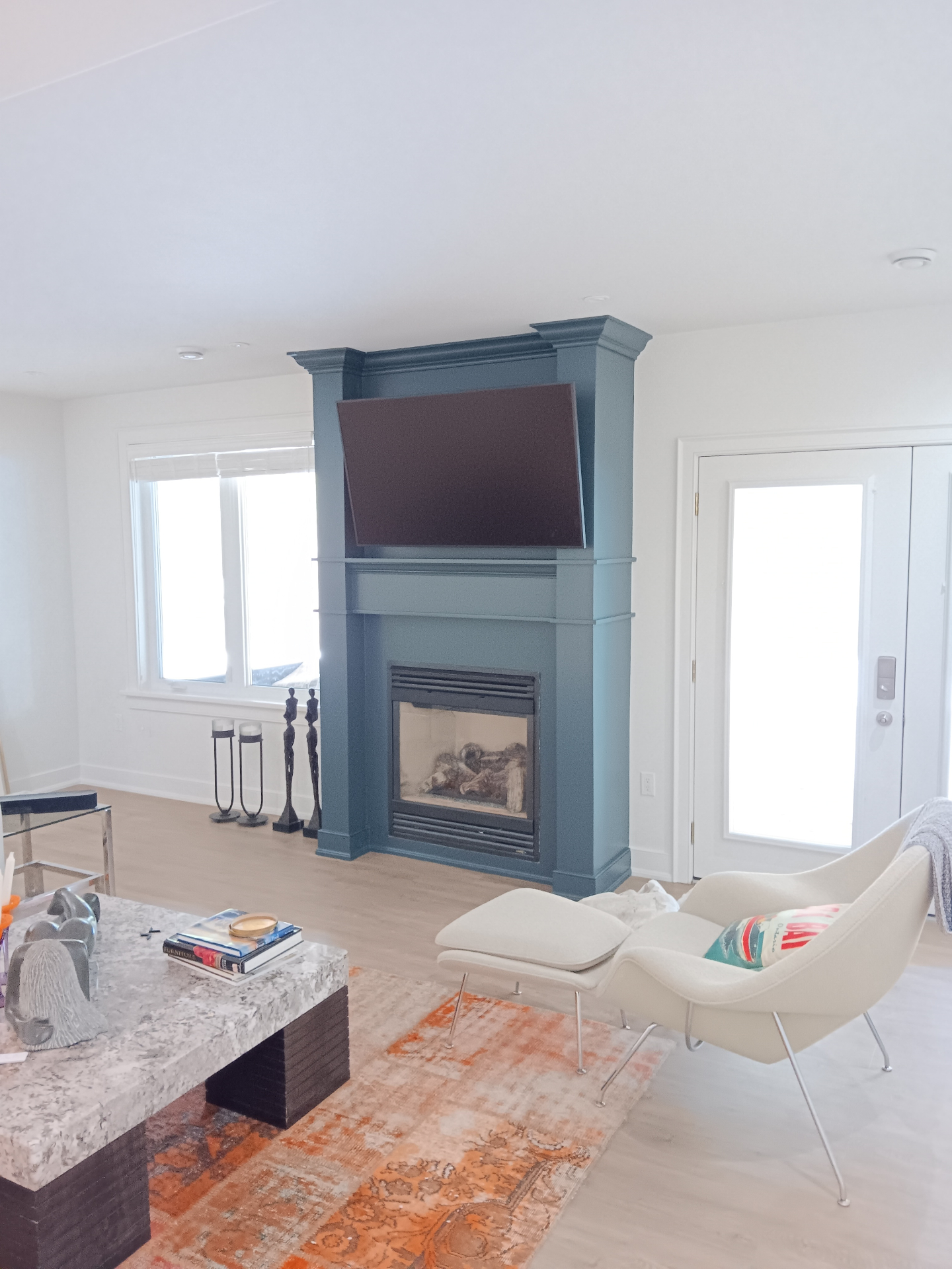 Custom painted blue fireplace surround with elegant crown molding in modern living room