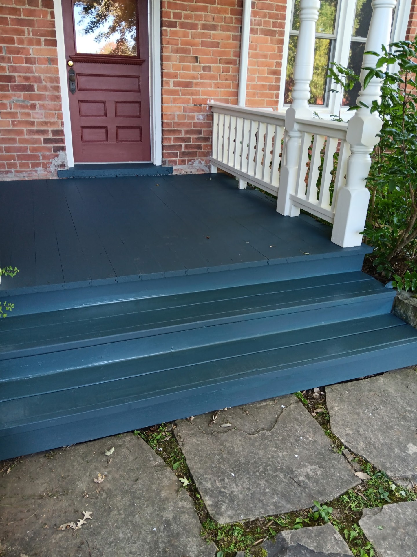 After porch repair and paint: beautifully finished teal porch with white railings